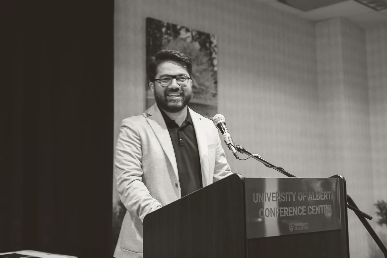 Muhammad Haseeb Arshad speaking from a lectern marked University of Alberta Conference Centre.